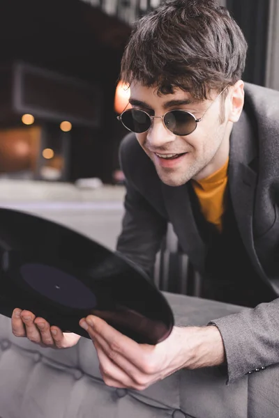 Glücklicher Junger Mann Mit Sonnenbrille Blickt Auf Retro Schallplatte — Stockfoto