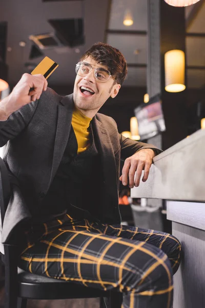 Homem Animado Óculos Sentado Balcão Bar Enquanto Segurando Cartão Crédito — Fotografia de Stock