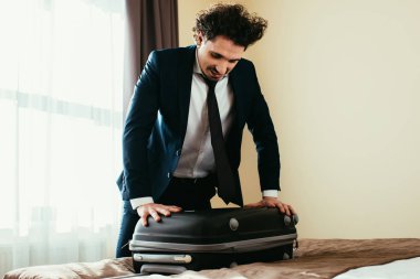 Otel Oda bavula ile takım elbiseli yakışıklı işadamı