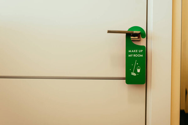 green sign with make up my room lettering on door handle, cleaning service