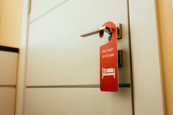 red "do not disturb" symbol on door handle in hotel