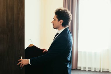 işadamı otel odasında gardırop giyim alarak takım