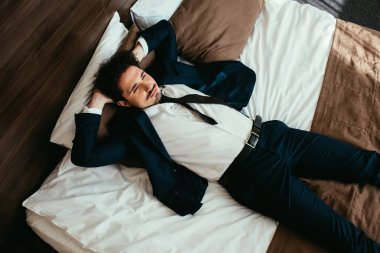 otel odasında yatakta uyuyan takım elbiseli işadamı Üstten Görünüm