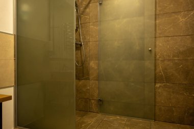 bathroom interior with brown tile and glass shower cabin clipart