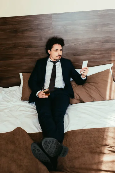 Adult Businessman Using Smartphone Holding Glass Cognac Bed Hotel Room — Stock Photo, Image