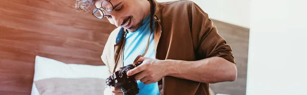 Lachende Mannelijke Fotograaf Kijken Fotocamera Hotelkamer — Stockfoto