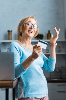 el ile eller ve kredi kartı laptop yakınındaki evde tutan bardaklarda sürpriz üst düzey kadın