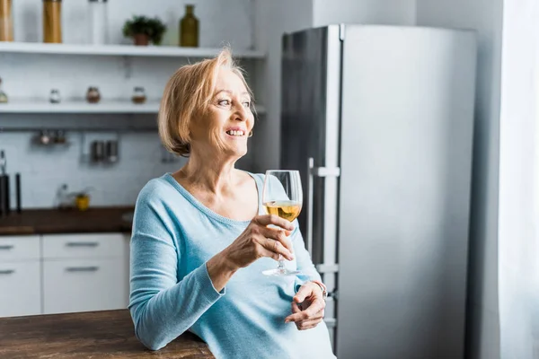 Sonriente Mujer Mayor Sosteniendo Copa Vino Cocina Con Espacio Para — Foto de Stock