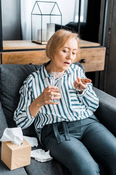 Nemocný Senior Žena Sedící Gauči Tkáně Box Držení Sklenice Vody — Stock fotografie