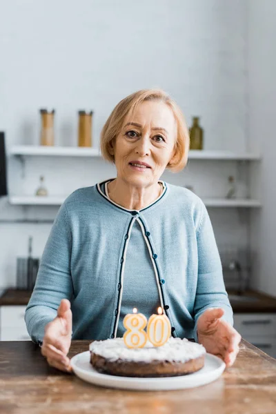 Senior Woman Looking Camera Holding Cake Sign Birthday Celebration Home — Stock Photo, Image