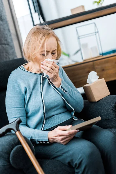 Traurige Seniorin Weint Und Wischt Sich Beim Betrachten Des Bilderrahmens — Stockfoto