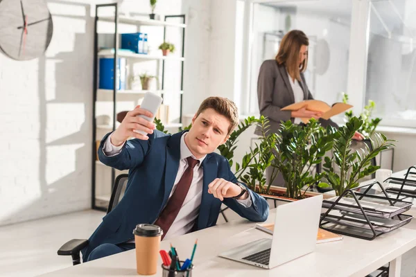 Selective Focus Handsome Man Taking Selfie Female Coworker Background — Stock Photo, Image