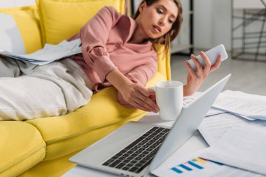 seçici odak smartphone kullanarak ve arka koltukta yatan kadın ile dizüstü