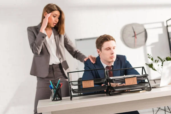 Selective Focus Businesswoman Holding Head Standing Tired Man Sitting Desk — Stock Photo, Image