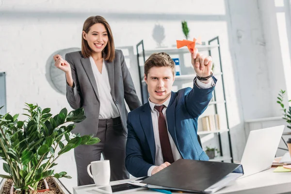 Feliz Empresaria Pie Mirando Alegre Compañero Trabajo Sosteniendo Avión Papel — Foto de Stock