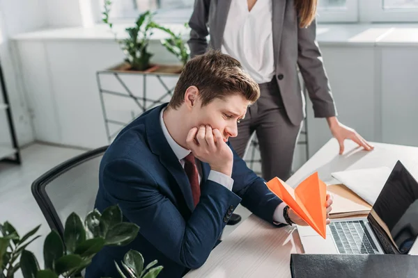 Cropped View Businesswoman Standing Sad Coworker Holding Paper Plane Office — Stock Photo, Image