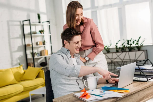 Cheerful Girlfriend Laughing Cheerful Boyfriend Pointing Finger Laptop Home — Stock Photo, Image