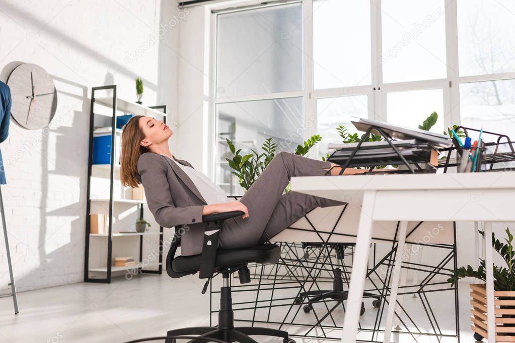  attractive businesswoman resting on chair in office