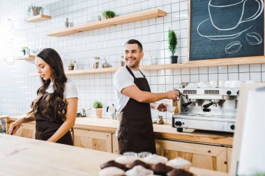 kahve yapma ve wile çekici kasiyer sayacı coffee House bar arkasında çalışan gülümseyen barista