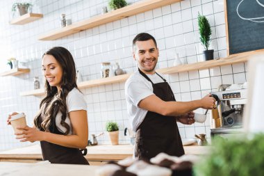 esmer çekici kasiyer kağıt Kupası wile barista kahve kahve evin içinde tutan