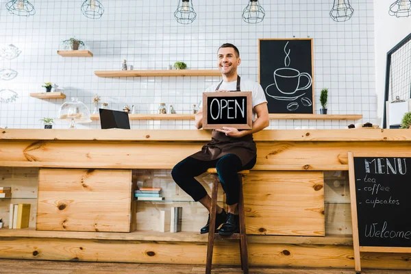 Handsome Cashier Apron Sitting Chair Wooden Bar Counter Smiling Holding — Stock Photo, Image