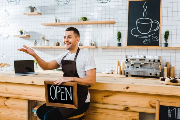 Handsome Cashier Apron Sitting Wooden Bar Counter Holding Chalkboard Open — Stock Photo, Image