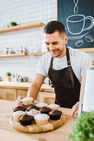 Handsome Waiter Standing Bar Counter Putting Cupcakes Wooden Tray Coffee — Stock Photo, Image