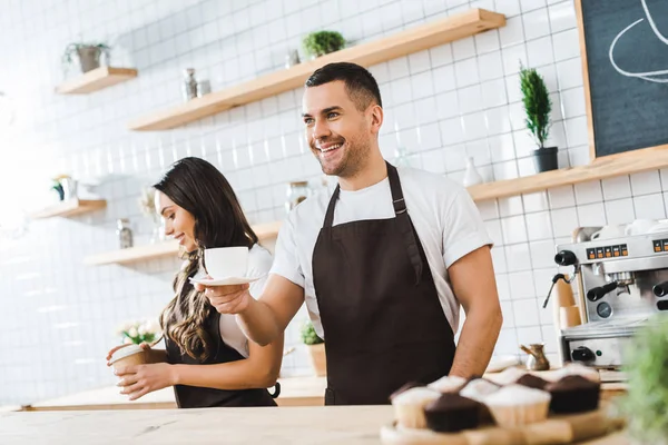 Handsome Cashier Holding Cup Saucer Wile Attractive Brunette Barista Closing — Stock Photo, Image