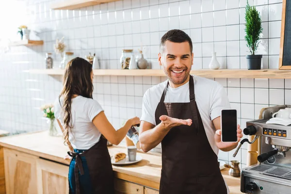 Handsome Cashier Pointing Hand Smartphone Blank Screen Wile Barista Working — Stock Photo, Image