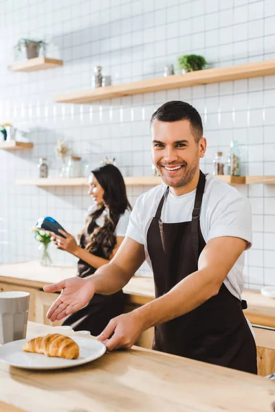 Bonito Barista Sorrindo Apontando Com Mão Para Caucasiano Wile Morena — Fotografia de Stock