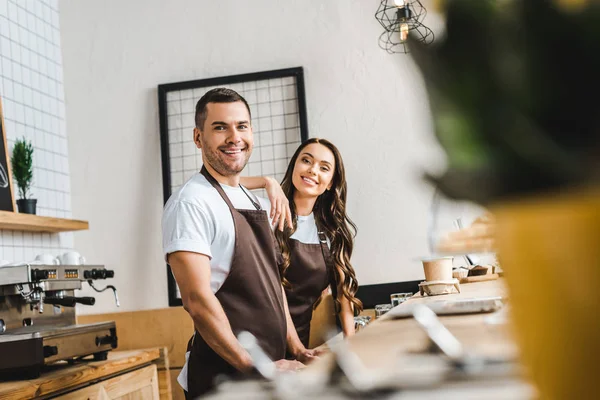 Foco Seletivo Caixas Aventais Castanhos Sorrindo Atrás Balcão Madeira Bar — Fotografia de Stock