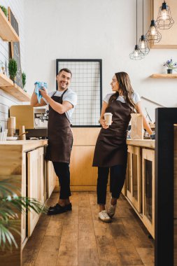 barista ve ayakta ve sayaç coffee House bar arkasında konuşurken önlük kasiyer