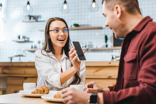 Attractive Brunette Woman Sitting Table Showing Smartphone Blank Screen Handsome — Stock Photo, Image