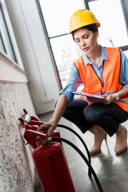 söndürücüler bakarken Pano ve kalem tutan kask içinde çekici itfaiye eri 