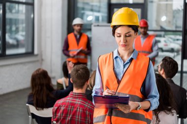seçici odak Pano iş arkadaşlarınızla konuşma brifing üzerinde arka plan üzerinde yakın tutan güzel itfaiye eri ve