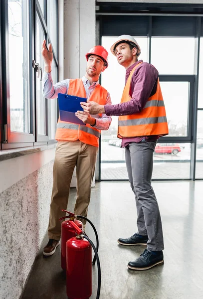 Firemen Helmets Talking While Standing Red Extinguishers — Stock Photo, Image