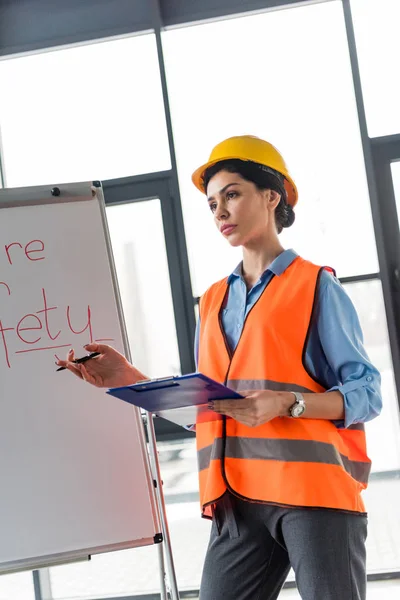 Serio Pompiere Donna Casco Che Tiene Appunti Penna Mentre Piedi — Foto Stock