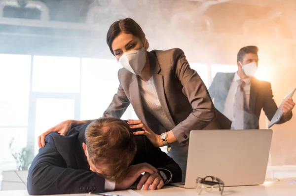 Selective Focus Terrified Woman Mask Standing Colleague Lying Desk Laptop — Stock Photo, Image