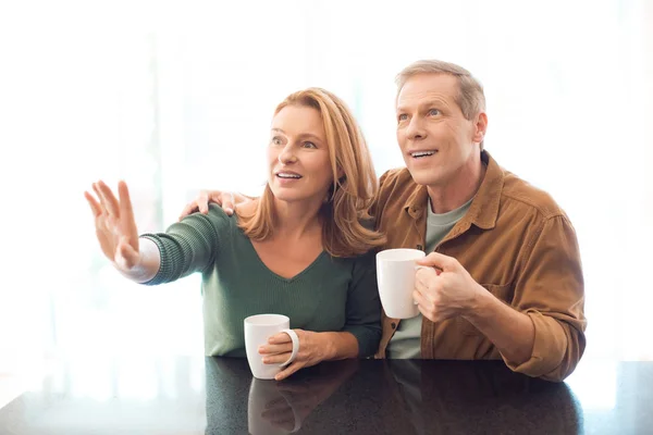 有选择的焦点夫妇拿着咖啡杯 而妇女指着手 — 图库照片