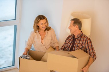 mutlu çift yeni evde karton kutuları açma sırasında söz