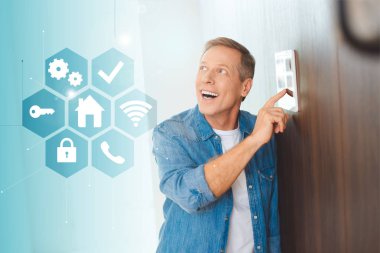 happy handsome man using smart house system control panel clipart