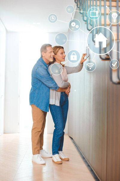 happy man hugging wife using smart house system control panel