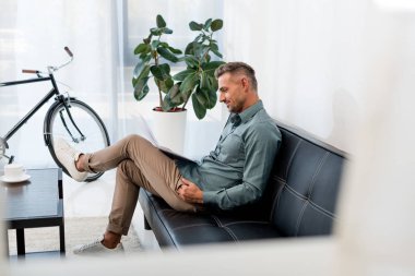 kanepede oturan ve gazete okuma yakışıklı işadamı seçici odak