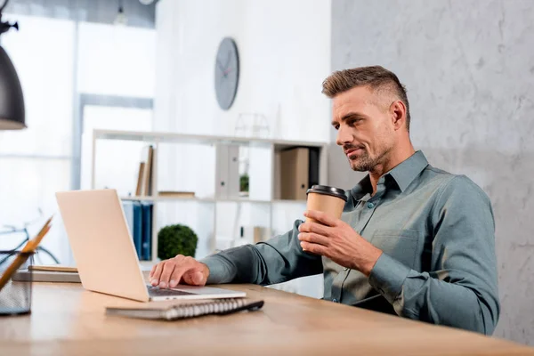 Selective Focus Handsome Businessman Holding Paper Cup While Using Laptop — Stock Photo, Image