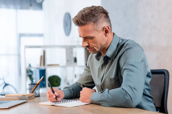 Bonito Homem Negócios Escrevendo Notebook Escritório Moderno — Fotografia de Stock