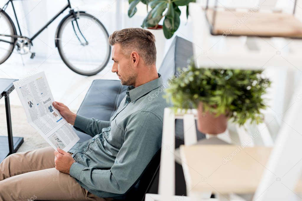 Selective focus of businessman reading business newspaper in office
