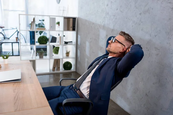 Pohledný Podnikatel Brýlích Relaxační Poblíž Přenosný Počítač Kanceláři — Stock fotografie