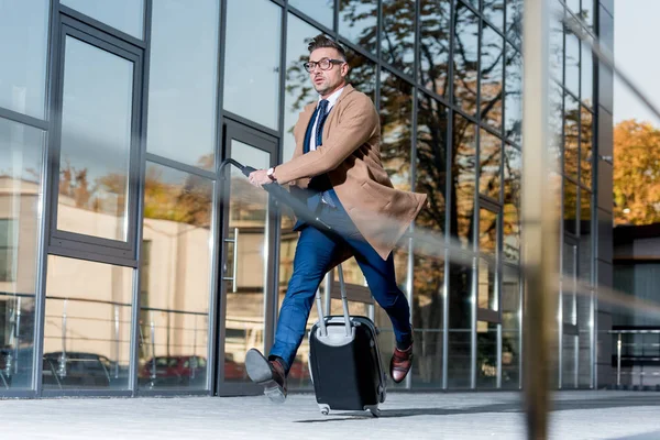 スーツとコートを搭載したスーツケースと傘路上でハンサムな実業家 — ストック写真