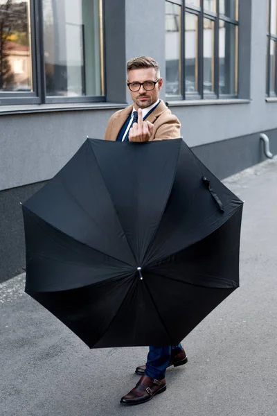 Knappe Zakenman Glazen Toont Middelvinger Terwijl Paraplu — Stockfoto