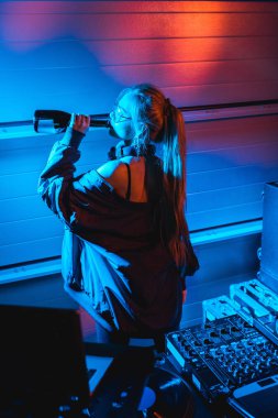 gece kulübünde şişe şarap içme çekici sarışın dj kız